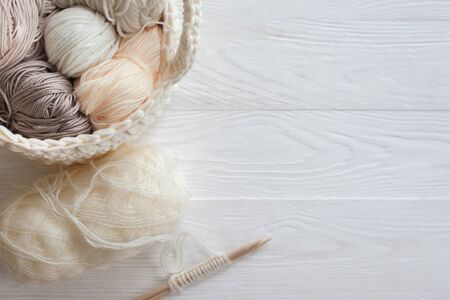 The beginning of the knitting process. Knitting needles. Basket with skeins of wool and cotton yarn....