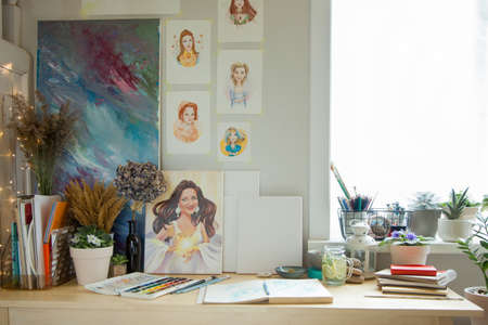 An illustrators workplace. Brushes, paints, sketchbooks and blank canvases.の写真素材