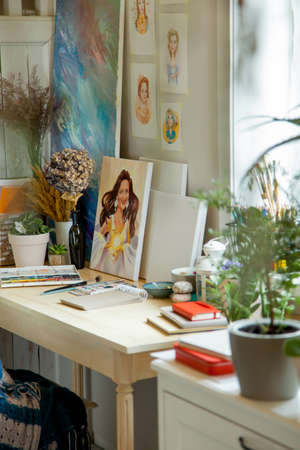 An illustrators workplace. Brushes, paints, sketchbooks and blank canvases.の写真素材