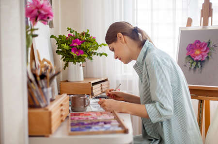 Side view of artist draws bouquet of rose and pink peony