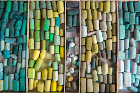 Top view of crayons of dry pastels in green shades