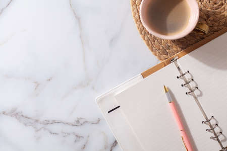 diary for the year 2021, pen, coffee, macaron cookie on straw woven placemat