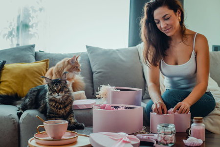 Young beautiful woman opens gifts at home. Valentines Day concept.の写真素材
