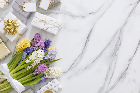 Top view trendy composition with festive wrapped gift boxes ribbon bow decorated by bloom flowersの写真素材