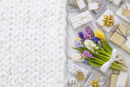 Top view trendy composition with festive wrapped gift boxes ribbon bow decorated by bloom flowersの写真素材