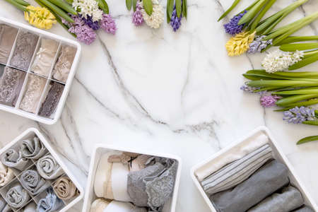 Stylish composition storage underwear organization Marie Kondos method decorated by natural flowers