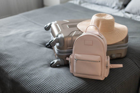 Modern suitcase full of things, handbag and straw hat. Baggage case packing getting ready to travelの写真素材