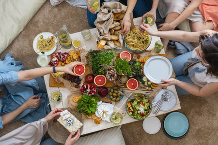 Top view group of happy woman friends posing together at hen-party with healthy food and drinkの写真素材