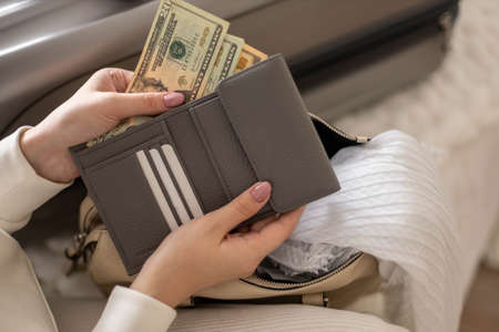 Female hands holding cash money dollars in wallet with cards ready travel vacation or business tripの写真素材