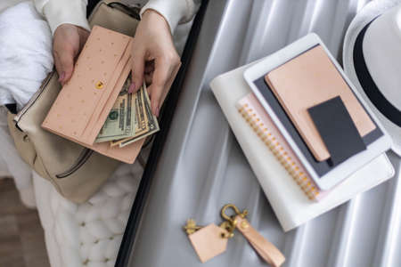 Top view woman hands counting checking cash money dollars and documents before leaving to vacationの写真素材