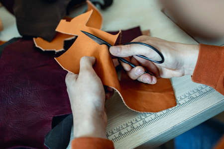 Craftsman cutting natural material use scissors. Working process at leather workshopの写真素材