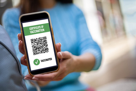 Portrait smiling woman posing with vaccine certificate on smartphone screen. Coronavirus preventionの写真素材