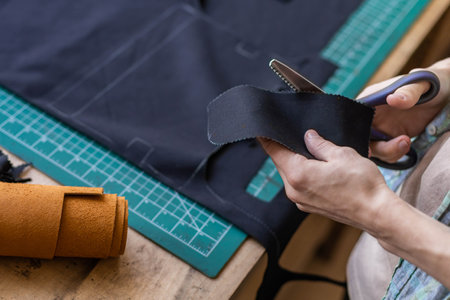 Craftsman drawing scheme lining for bag on tissue creating leatherwork at studio leather workshop