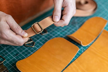 Process cutting scheme of bag with equipment and materials. Male tanner working at leather workshopの写真素材