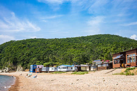 Funny kid boy floating on inflatable rubber strawberry lifebuoy surrounded by pure clear sea waterの写真素材