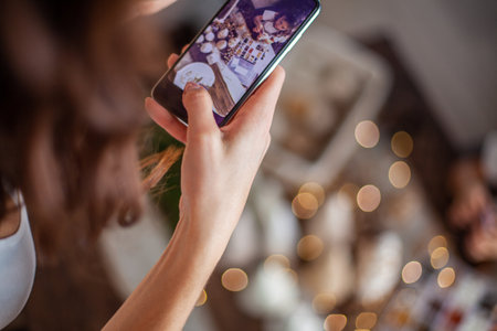 Woman hands is taking pictures on phone the Christmas composition with handcrafted Christmas Tree.の写真素材