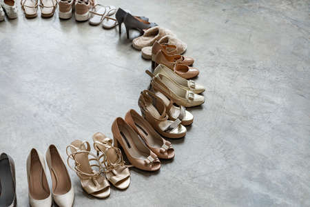 Top view many colored female shoes on gray floor footwear wheel fashion stylish footgear choosingの写真素材