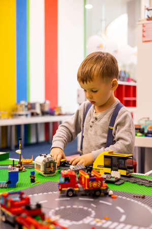 Little boy plays color Lego set on the table. Early training and development.のeditorial素材