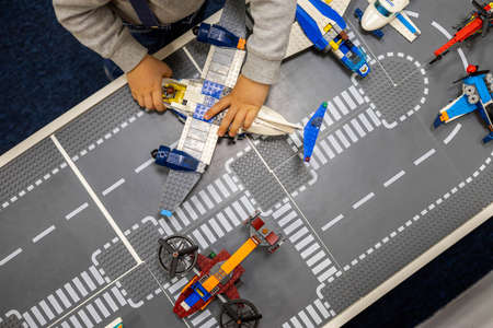 Little boy plays color Lego set on the table. Early training and development.のeditorial素材