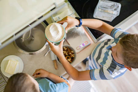 Top view baby brothers kids cooking dessert together use fresh healthy ingredients at kitchenの写真素材
