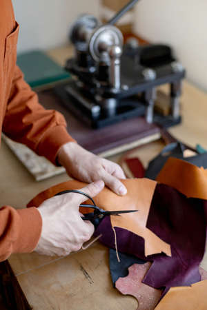 Craftsman cutting natural material use scissors. Working process at leather workshopの写真素材