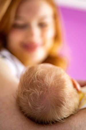 Portrait adorable smiling redhead mother posing with newborn baby feeling love enjoying motherhood