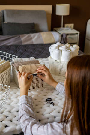 Woman hands neatly folded linens and towels use Marie Kondo method with sticky label tagsの写真素材