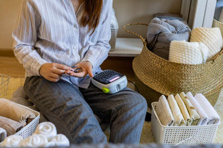 Woman neatly folded linens and towels use Marie Kondo method with sticky label tagsの写真素材