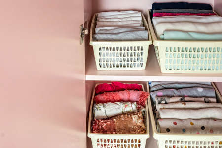Closeup shelves pink female childish closet with neatly folded clothesの写真素材