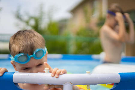Little boy toddler in the pool with bright swimming circles.