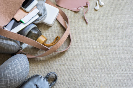 Laying travel luggage ready to plane on copyspace textured canvas background top view