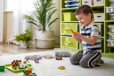 Khabarovsk, Russia, February 18, 2022. Boy constructs Lego at childrens room toy storage systemのeditorial素材