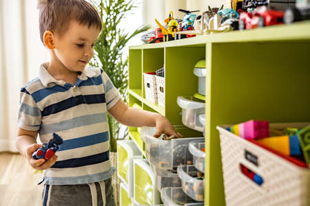Khabarovsk, Russia, February 18, 2022. Boy sorting Lego constructor into boxes at childrens roomのeditorial素材