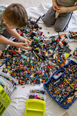 Khabarovsk, Russia, February 18, 2022. Male kids sorting multicolored Lego details into boxesのeditorial素材