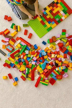 Khabarovsk, Russia, February 25, 2022. Top view cute baby boy playing Lego Duplo multicolored pieces