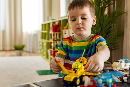 Khabarovsk, Russia, February 25, 2022. Male kid constructing toy cars and planes use Lego Classic
