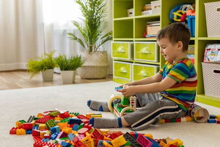 Khabarovsk, Russia, February 25, 2022. Smiling male kid constructing toy car with Lego Duplo detailsのeditorial素材