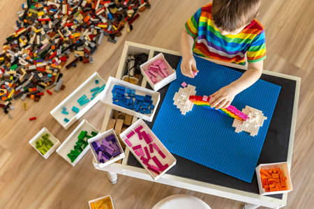 Khabarovsk, Russia, February 25, 2022. Confident baby boy constructing rainbow use Lego Classicのeditorial素材