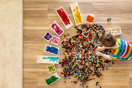 Khabarovsk, Russia, February 25, 2022. Cute baby boy sorting Lego Classic pieces to colorsのeditorial素材