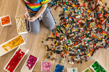 Khabarovsk, Russia, February 25, 2022. Cute baby boy sorting Lego Classic pieces to colorsのeditorial素材