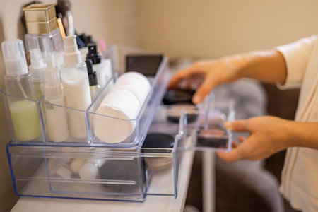 Closeup female hands putting luxury cosmetic into acrylic box with drawer storage organizationの写真素材