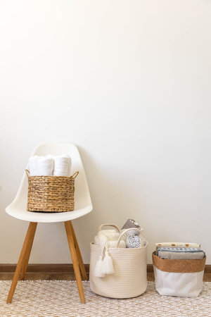 Neatly folded rolled soft textile towels bed linens in eco friendly baskets Nordic minimalismの写真素材