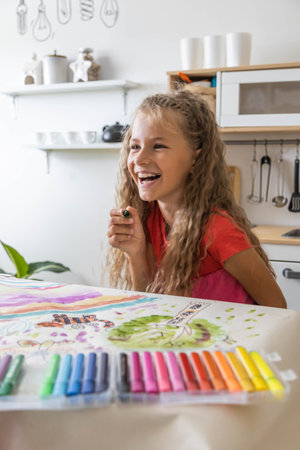 Laughing blonde curly little girl drawing paper art picture chalks sitting on near childish hovel