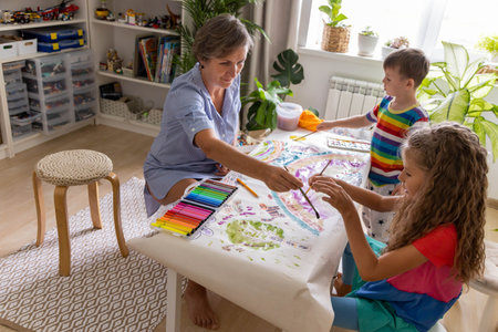 Family mother and kids drawing art picture on paper with multicolored chalks enjoy weekend