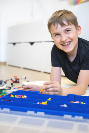 Khabarovsk, Russia, June 4, 2022. Confident male adolescent constructing Harry Potter Legoのeditorial素材