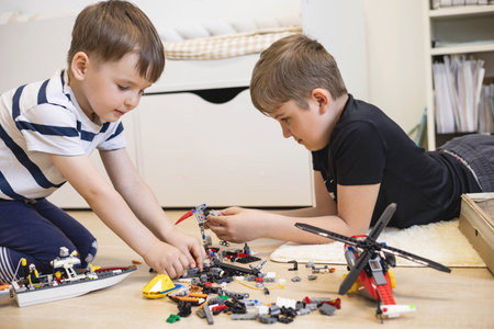 Khabarovsk, Russia, June 4, 2022. Cute baby boy constructing helicopter Lego pieces at childish roomのeditorial素材