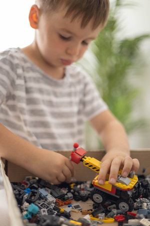 Khabarovsk, Russia, August 07, 2022. Male kid constructing toy excavator and use Lego Classicのeditorial素材