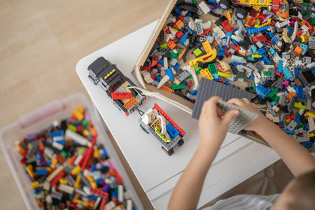 Khabarovsk, Russia, August 07, 2022. Male kid constructing toy excavator and use Lego Classic