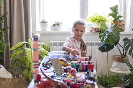 Khabarovsk, Russia, August 26, 2022. Cute girl child constructing toy cars and use Lego Classicのeditorial素材