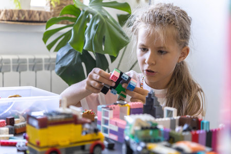 Khabarovsk, Russia, August 26, 2022. Cute girl child constructing toy cars and use Lego Classicのeditorial素材